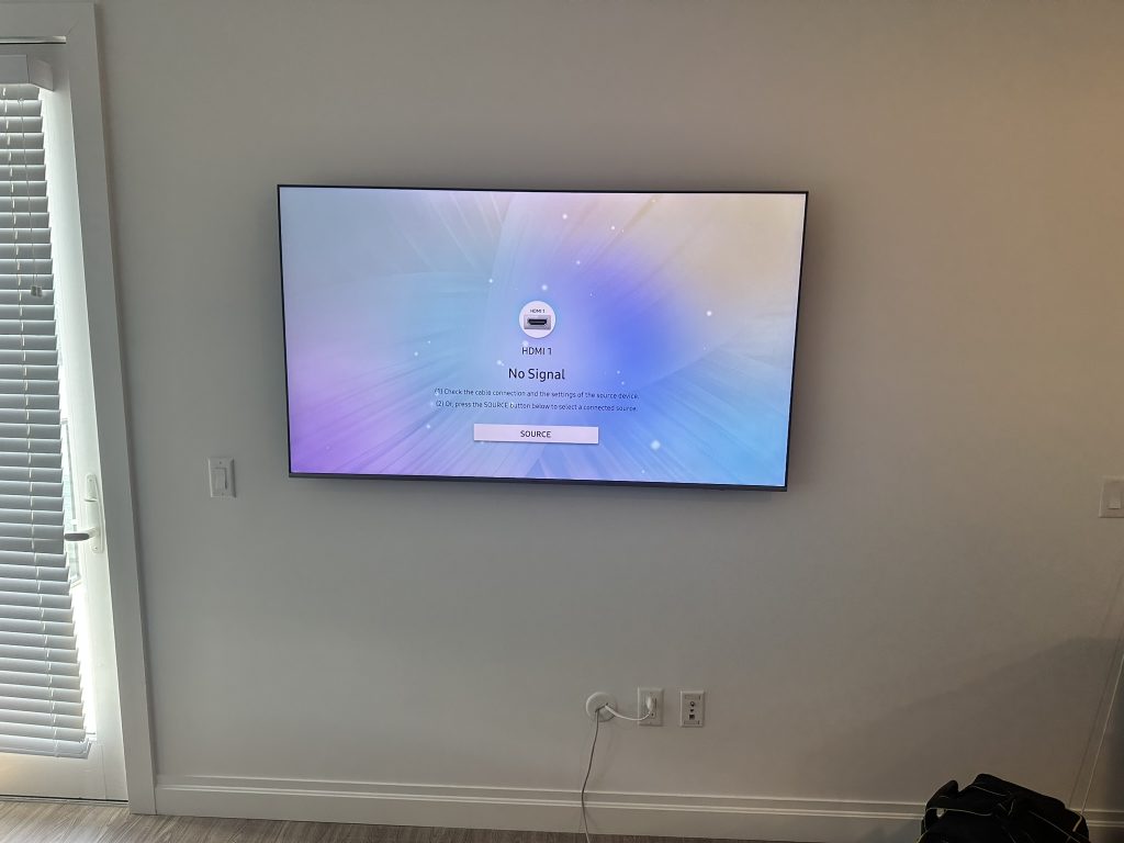 65 inch Samsung Frame TV mounted flush to the wall with a flat mount and hidden in wall cables in Manhasset, NY