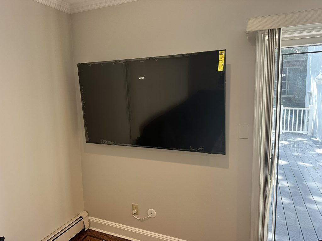 65 inch Samsung OLED TV freshly mounted with a full motion bracket and concealed in wall cables in Port Washington, NY