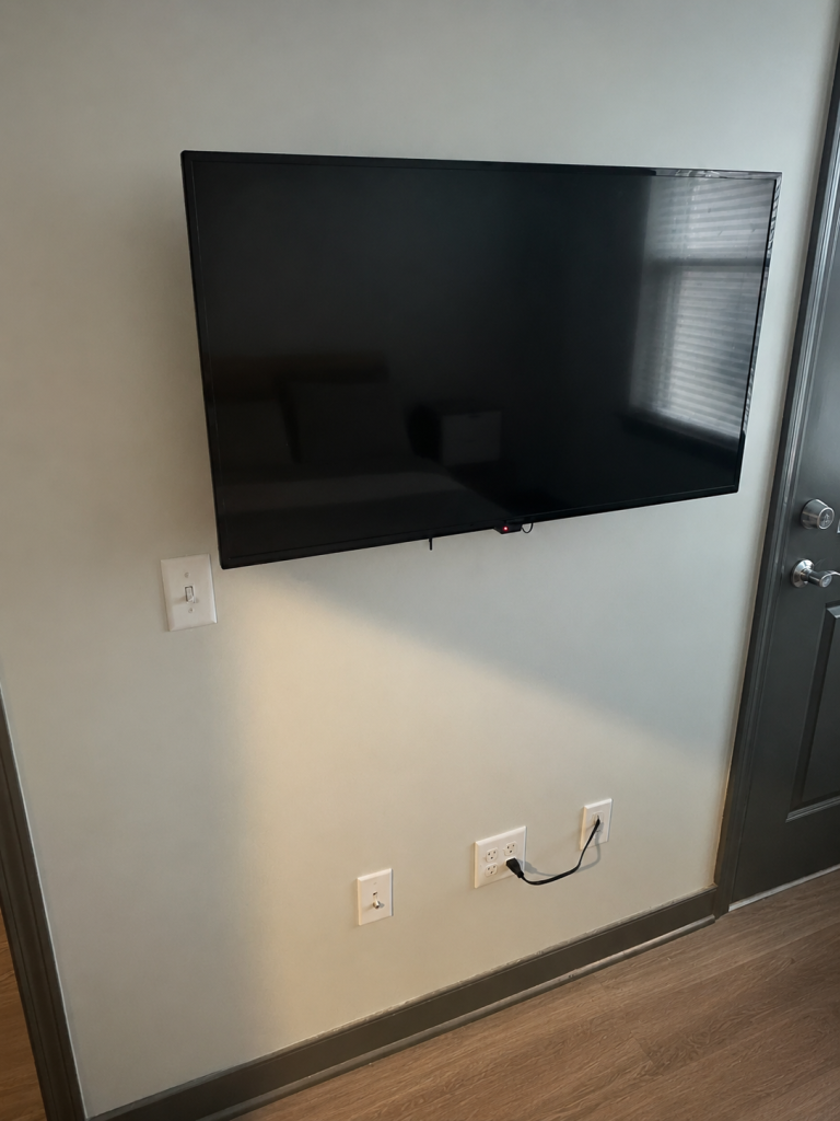 65 inch Samsung TV flush mounted with a full motion bracket and concealed in wall cables in Long Beach, NY