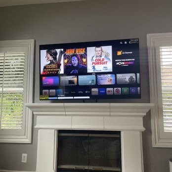 65 inch Sony TV positioned on a full motion mount above the fireplace in Mineola, NY