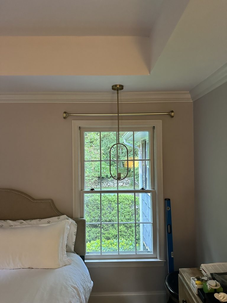 Designer curtain rods and ceiling pendant light installed in a bedroom in Roslyn, NY
