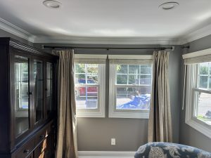 Designer curtain rods and layered window shades installed in a living room in Huntington, NY