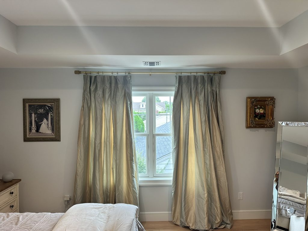 Stylish curtain rod with flowing drapes installed in a bedroom in Massapequa, NY